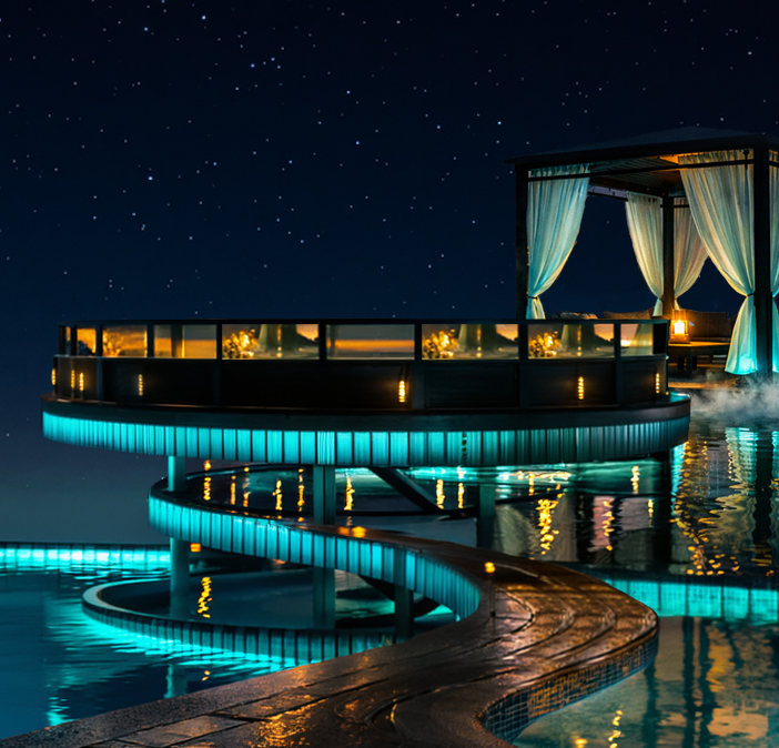 Circular illuminated stage platform over the glowing pool at night